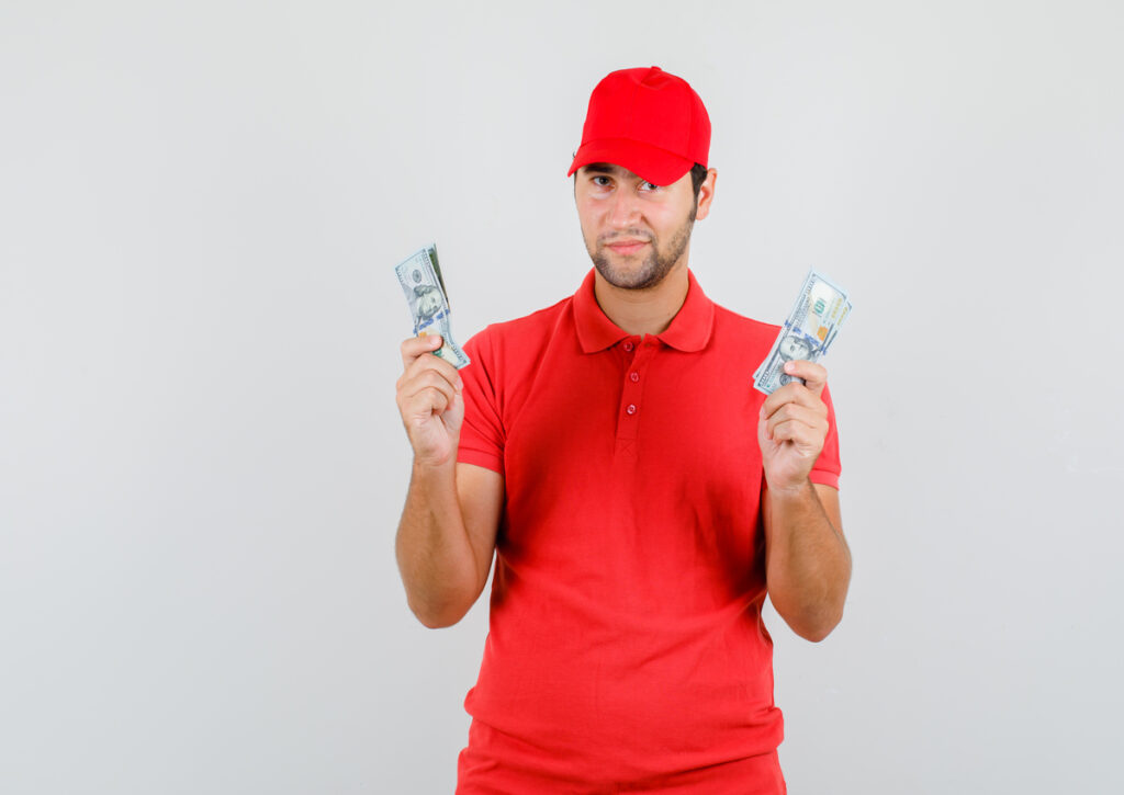 A locksmith holding money bills on both hands as payment for his service