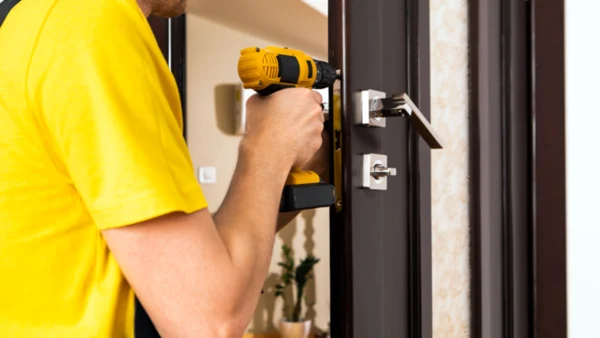An emergency locksmith fixing the doorknob
