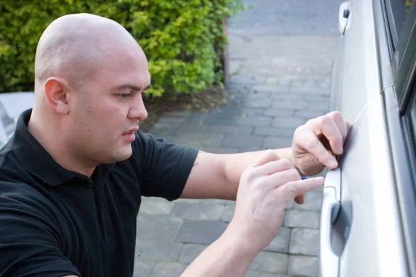 A professional locksmith unlocking a car
