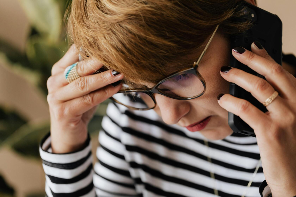 A woman using a phone to call a locksmith