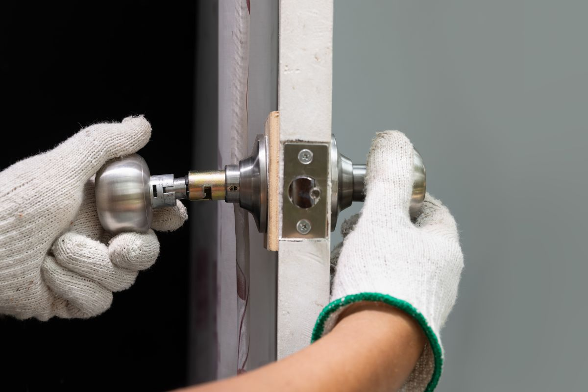 Locksmith repairing door knob.
