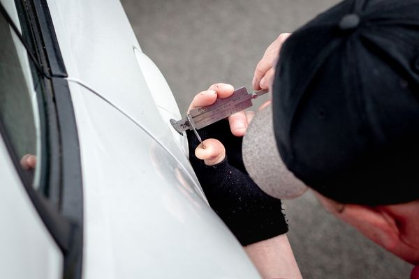 Locksmith unlocking car door with tools