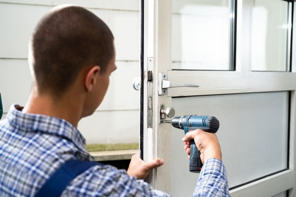 Professional locksmith fixing home door lock