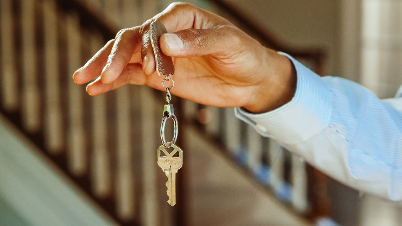 Person holding a silver keychain with a key