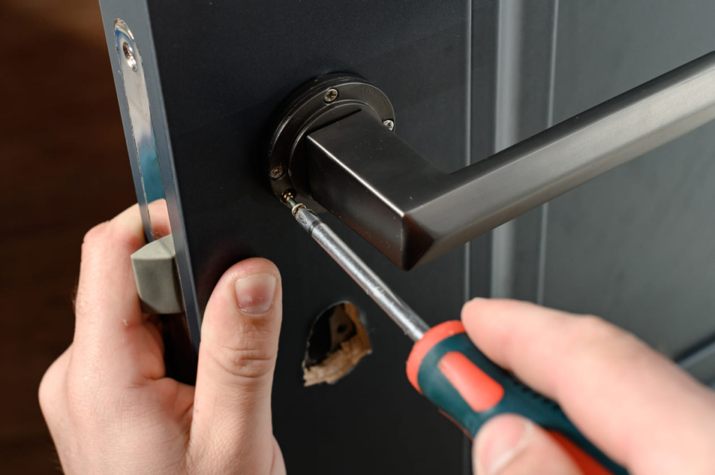Locksmith repairing door lock.