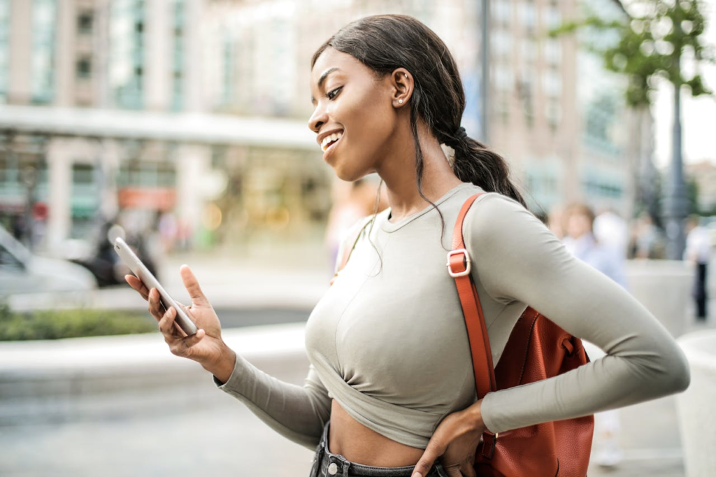 A woman holding a smartphone searching for nearby emergency locksmiths