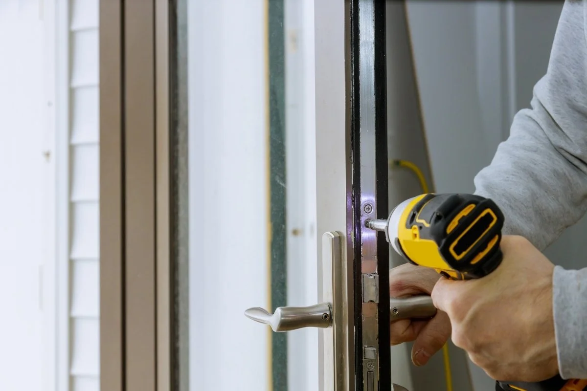 Commercial locksmith repairing a building door 