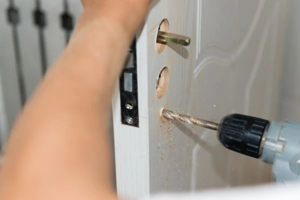 Locksmith working with drilling tools