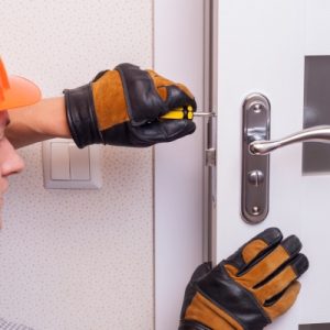 Locksmith fixing a door lock.